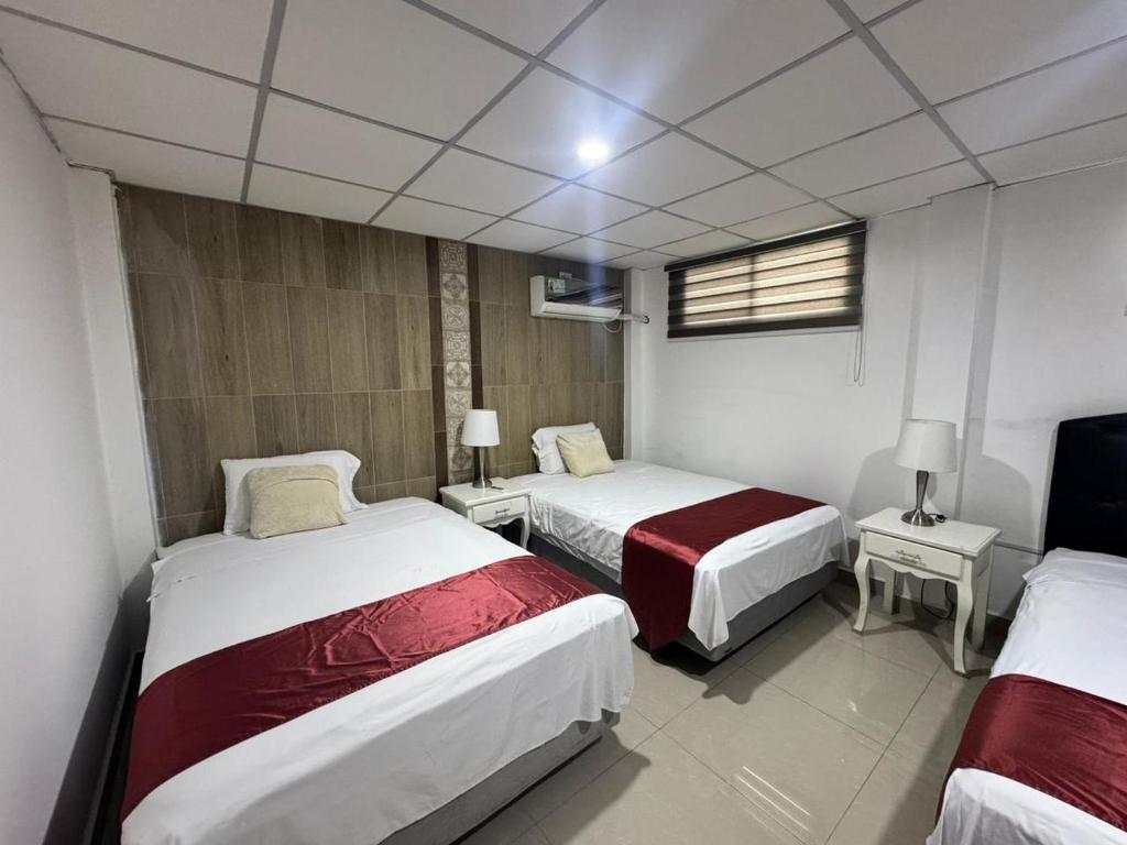 Una habitación de hotel con dos camas y un televisor. en The Royalty Lite, en Guayaquil