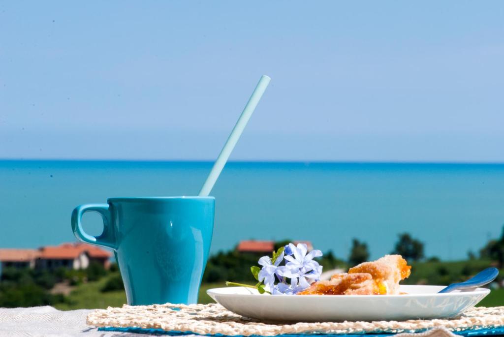 uma mesa com um prato de comida e um copo azul em Vistazzurra B&B em Ancona