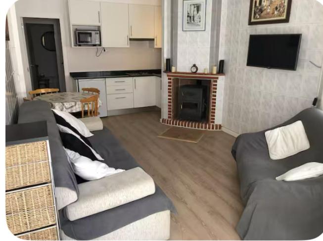a living room with a couch and a kitchen at Casa Emilia in Talayuelas