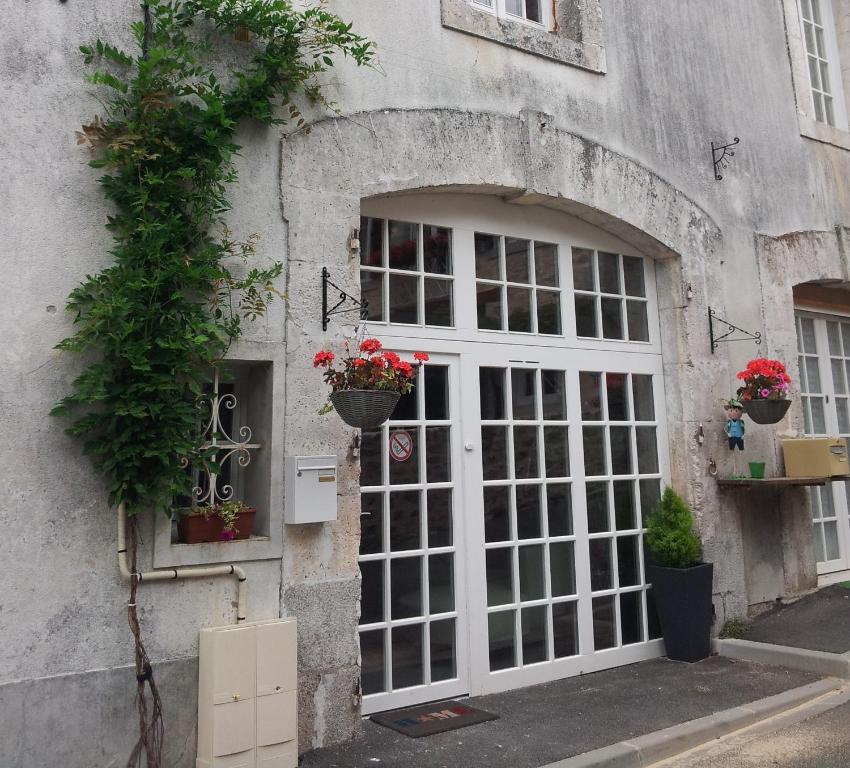 eine Tür zu einem Gebäude mit Blumen darauf in der Unterkunft La Belle Maison in Piégut-Pluviers