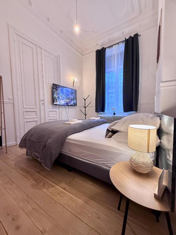 a bedroom with a large bed and a table at European Lodge Rooms Brussels in Brussels