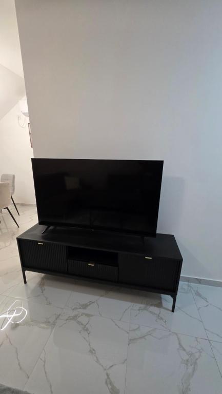 a black entertainment center with a flat screen tv on it at Flower Apartman in Veternik