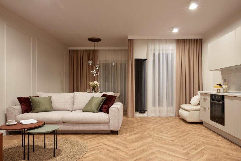 a living room with a white couch and a kitchen at Apartament Hugo - Stare Miasto - Garaż Gratis !!! in Elblag