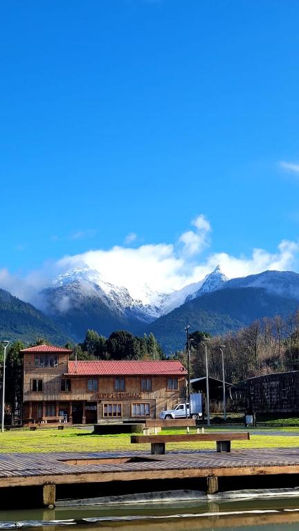 Ein Gebäude vor dem Hintergrund schneebedeckter Berge in der Unterkunft Hotel Cochamó in Cochamó