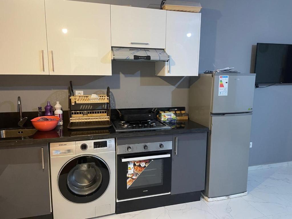 een keuken met een wasmachine en een koelkast bij Résidence Picasso in Casablanca