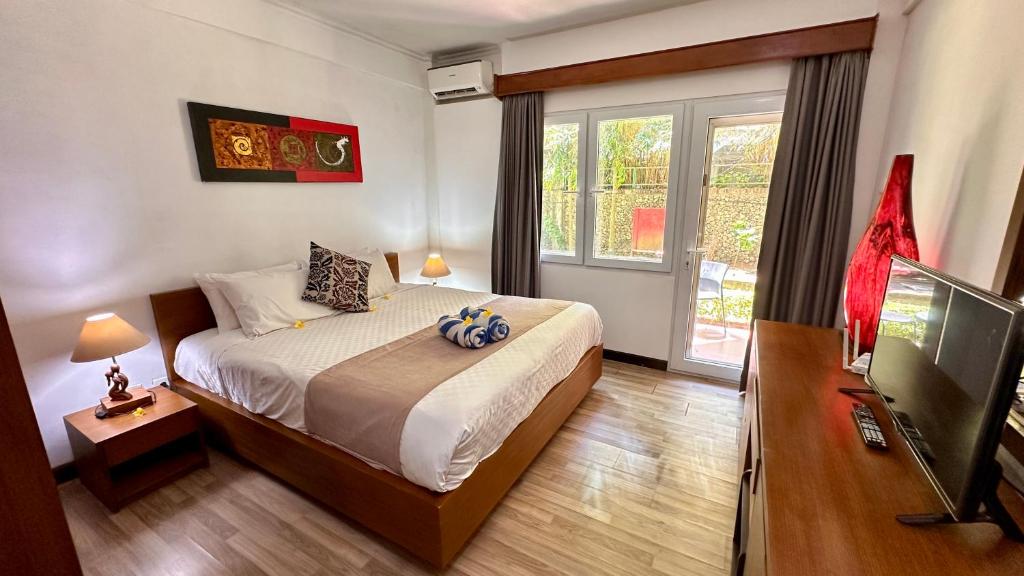 a bedroom with a bed and a large window at Nattaya at the Jayakarta Bali in Seminyak