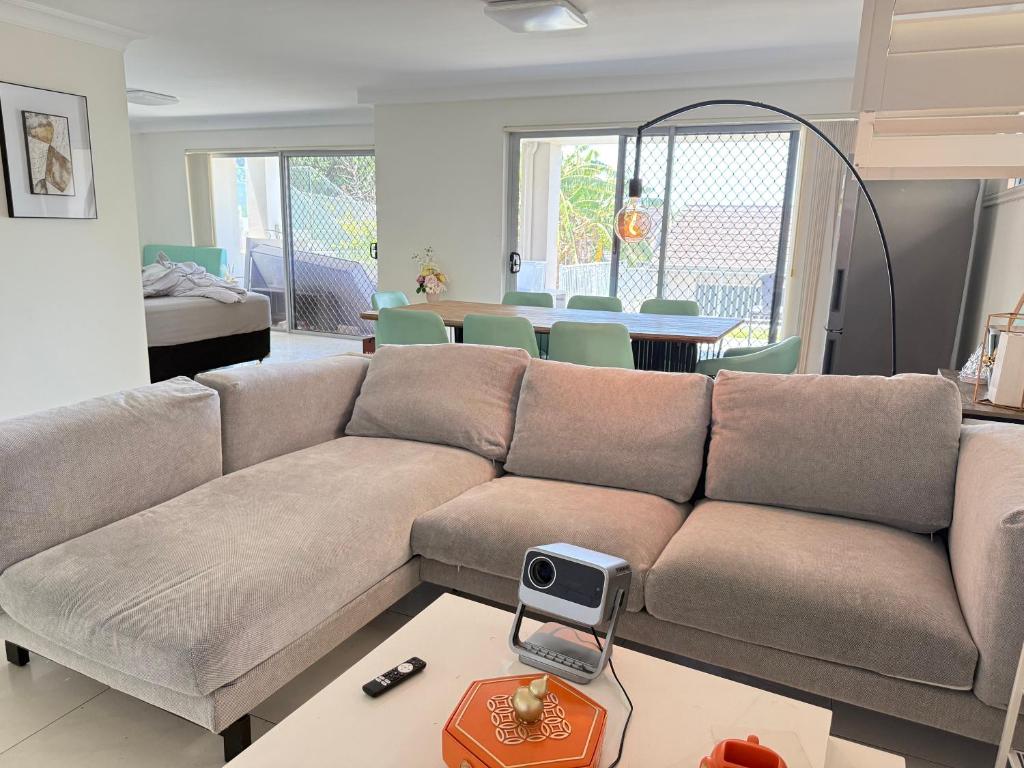 シドニーにあるUrban Silver Haven Sleek stay - 1 Min to Station With TV projector Game space and high speed internetのソファとテーブルのあるリビングルーム
