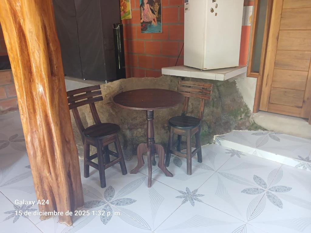 una mesa pequeña y dos taburetes en una cocina en Chema, en Mocoa