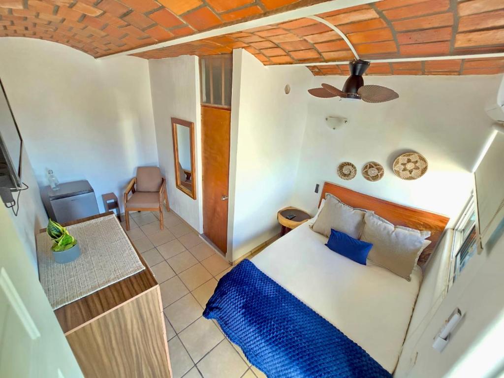 una camera da letto con un letto e una sedia in una stanza di Tayau Bungalows B8 a Lo de Marcos