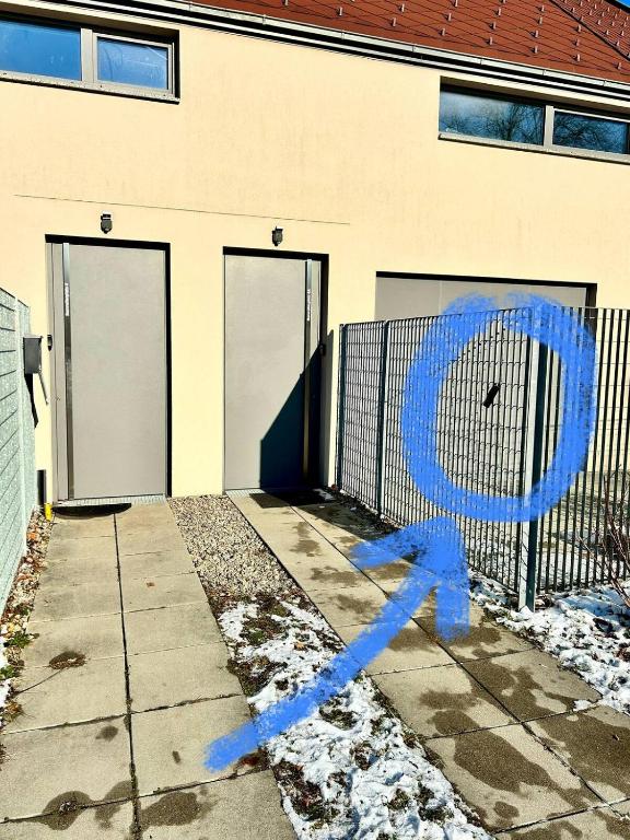 un edificio con una valla con una señal azul en Stylish Apartment near Airport, en Schwechat