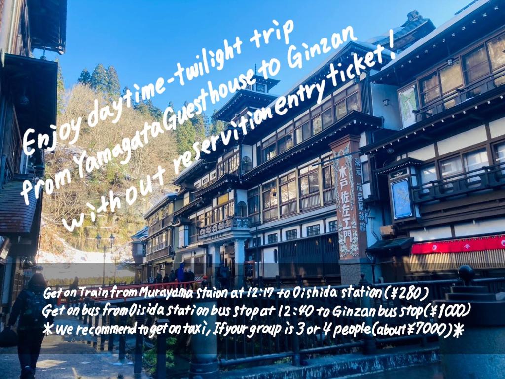 a building with a sign on the side of it at Yamagata Guesthouse山形ゲストハウス in Murayama