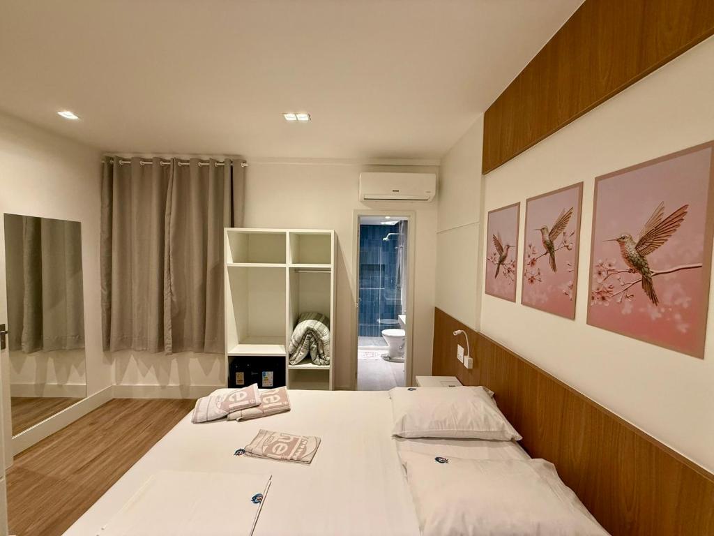 een slaapkamer met een groot bed met witte lakens bij Hotel Sheik Business in Rio de Janeiro