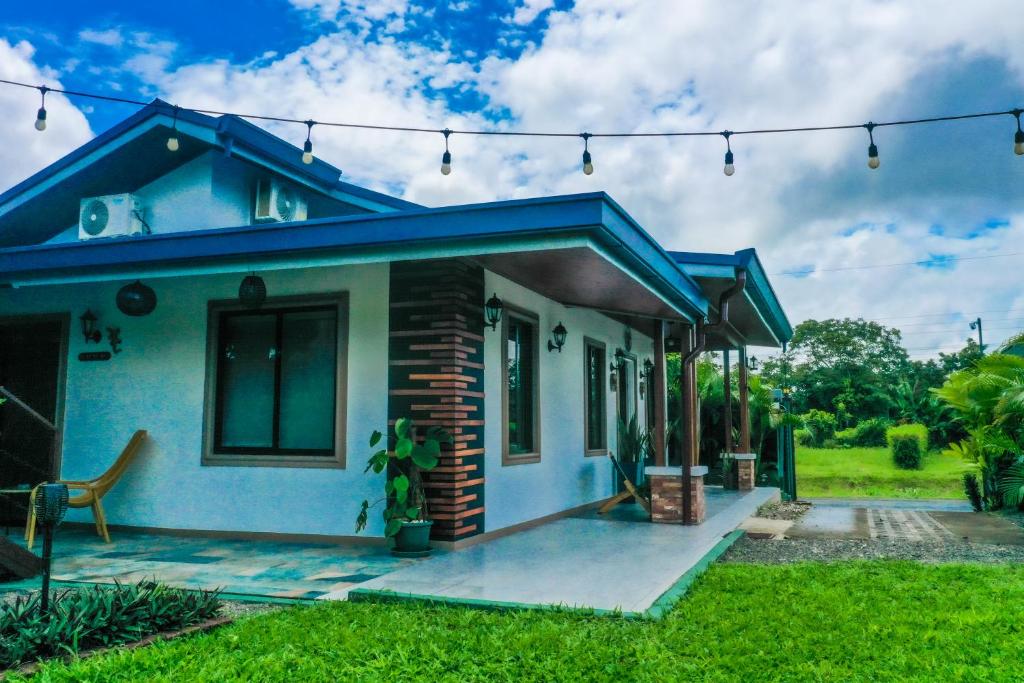 a small blue house with a blue roof at House Monstera Arenal in Agua Azul
