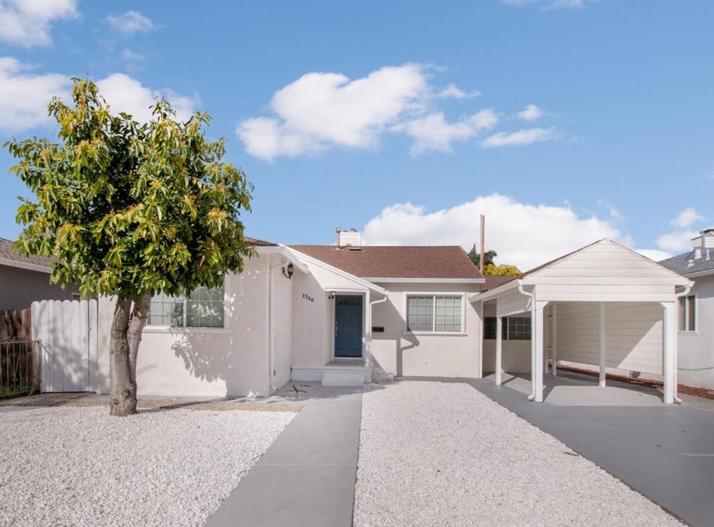 una casa blanca con un árbol delante en Downtown San Jose Airport Shared Home, en San José