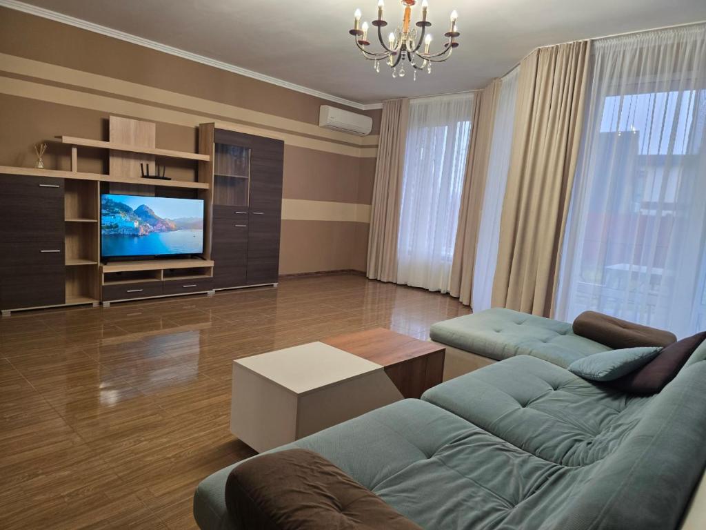 een woonkamer met een bank en een tv bij Royal Residence Uzhhorod in Oezjhorod