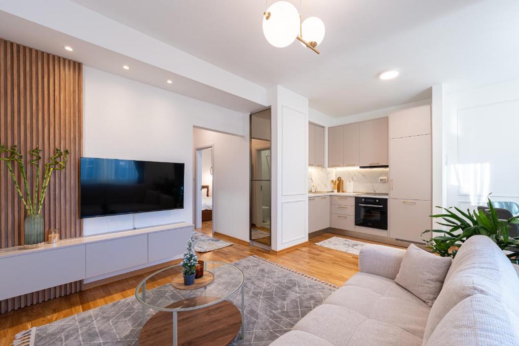 ein Wohnzimmer mit Sofa und Fernseher in der Unterkunft Quince Apartments in Podgorica