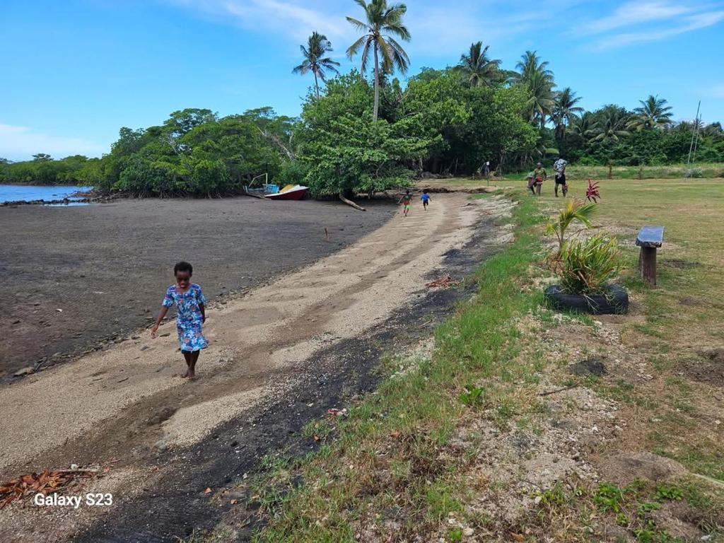 un bambino che cammina lungo una strada sterrata di Sunshine Villas 