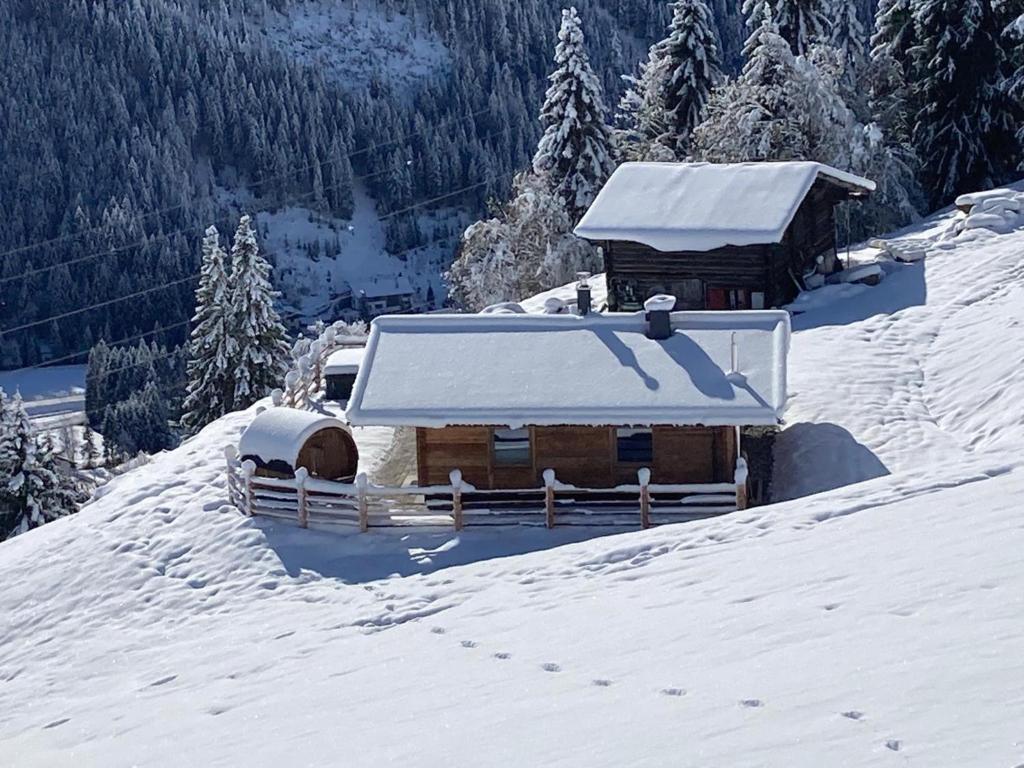 Cabaña cubierta de nieve en la cima de una montaña cubierta de nieve en Siedelhütte, en Gerlos