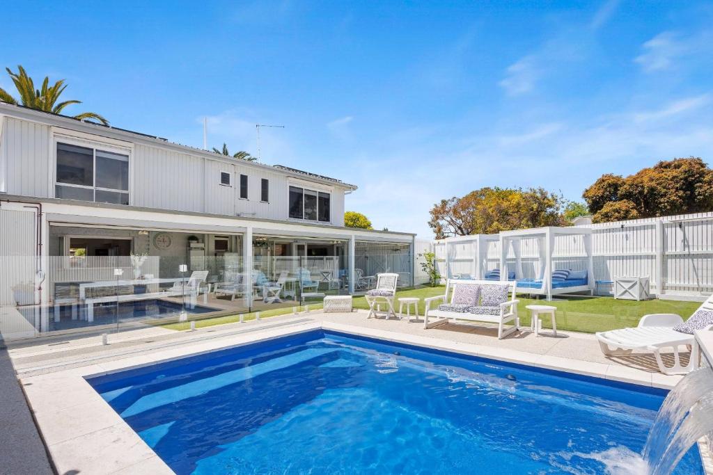 una piscina en el patio trasero de una casa en SANTORINI BEACH HOUSE SAFETY BEACH, en Safety Beach