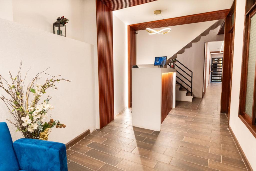 Un pasillo con una silla azul y escaleras. en Los Faroles Zona 3, en Cobán