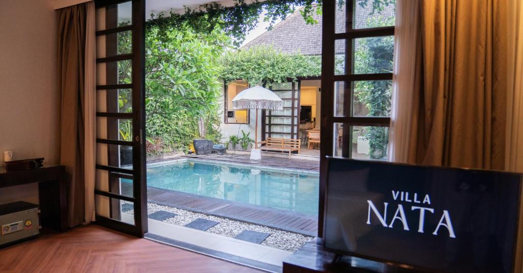 a view of a swimming pool through a sliding glass door at Villa Nata Umalas in Seminyak