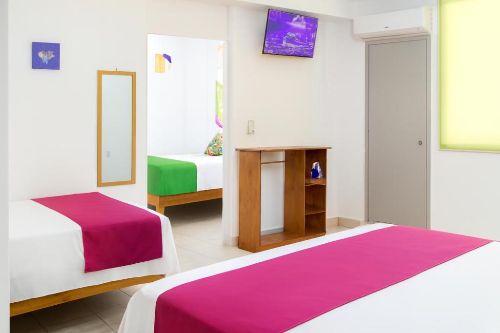 Un dormitorio con dos camas y un espejo. en Hospedaje Aldana Apartamento AURA Centro Histórico, en Tuxpan de Rodríguez Cano