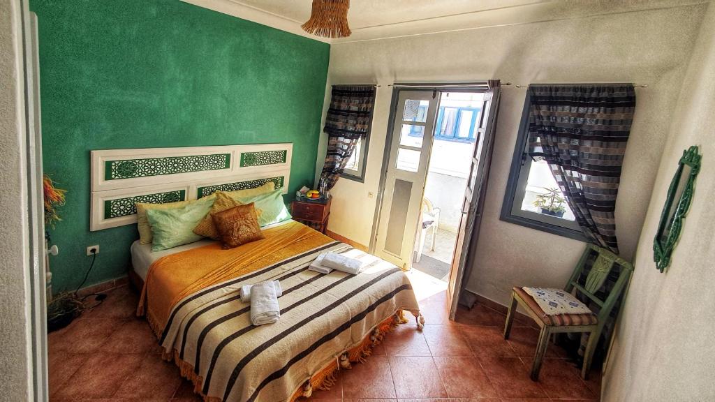 Un dormitorio con una cama y una pared verde. en Ocean Hideaway - Sea View, en Essaouira