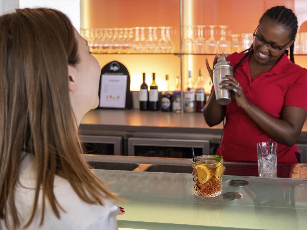 un uomo e una donna in piedi in cucina che preparano un drink di ibis Antwerpen Centrum ad Anversa