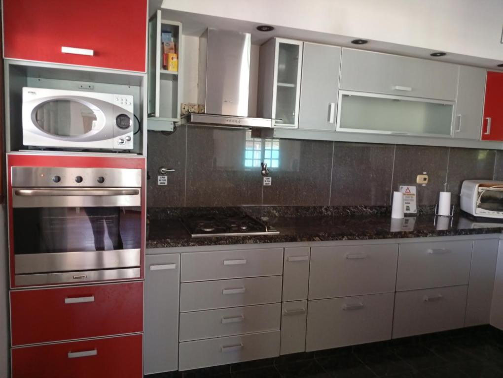 a kitchen with white cabinets and a microwave at Aires Verdes in General Pico