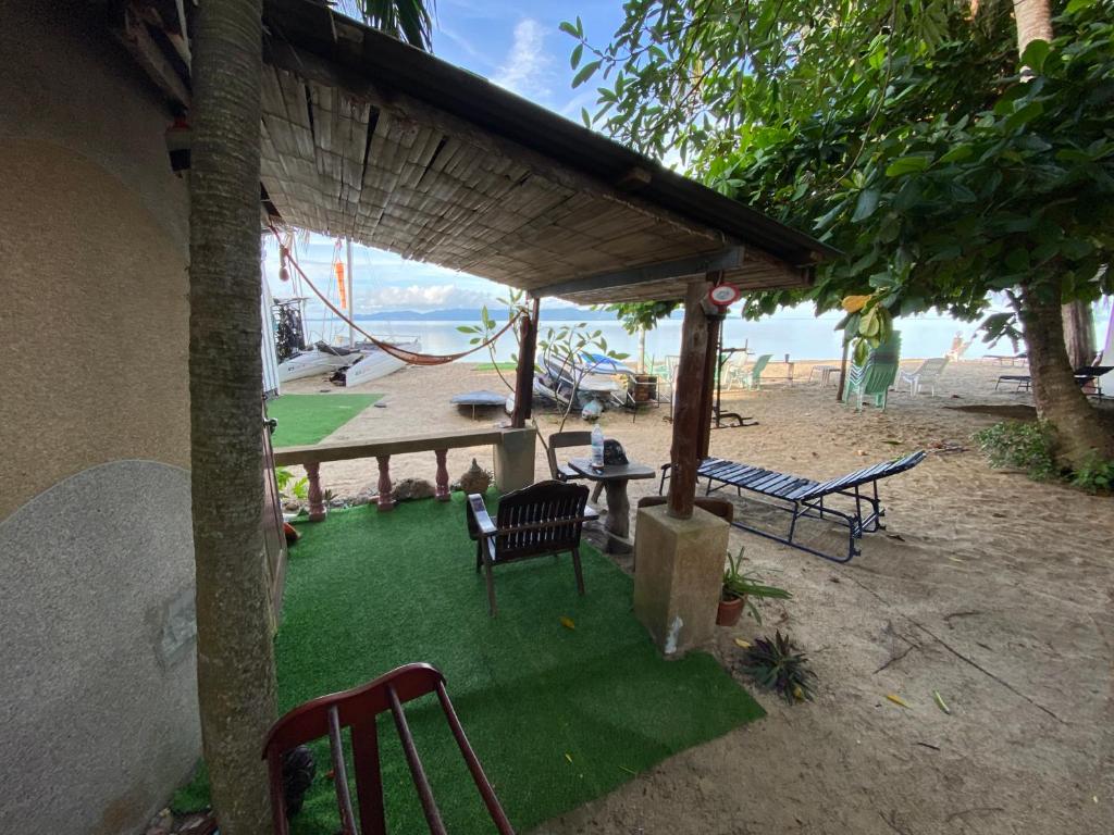 een patio met stoelen en een tafel op het strand bij Nomad Soul Bungalow in Ko Pha Ngan