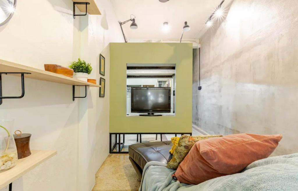 a living room with a couch and a tv at Bang Chak Studio in Bangkok