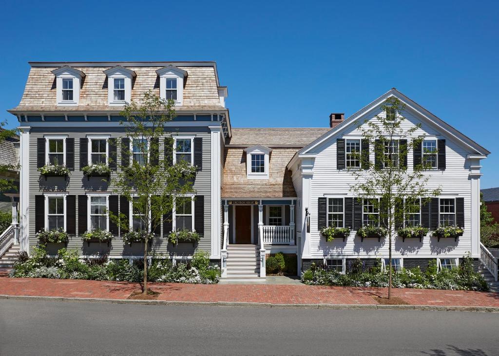 una casa blanca con persianas negras en una calle en Greydon House en Nantucket