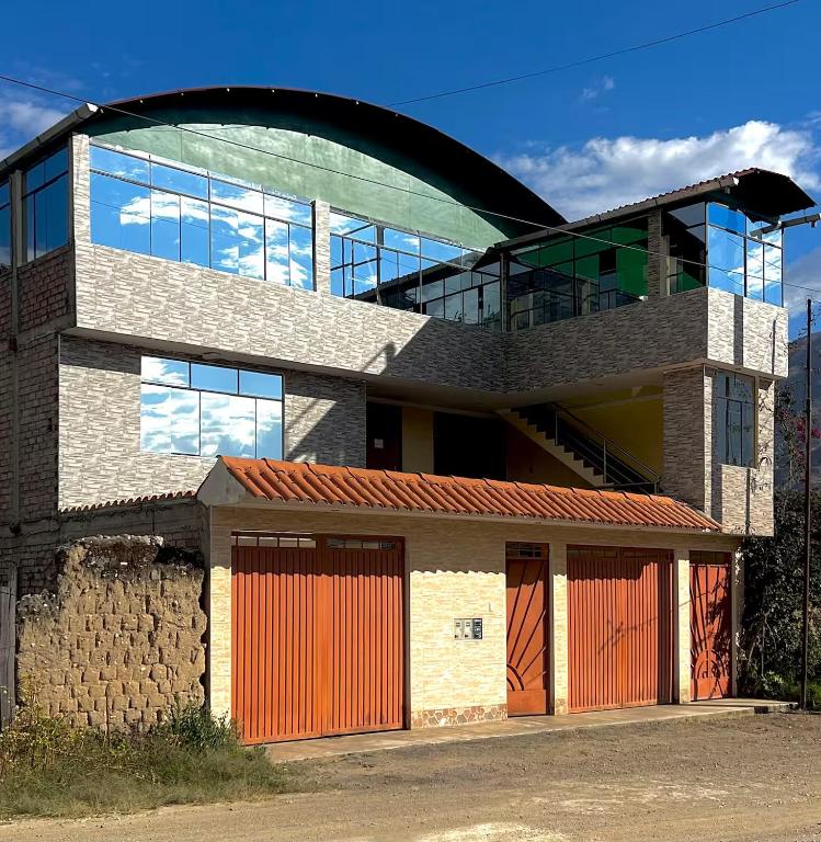 a building with orange garage doors and a glass building at Hotel Shumaq Yungay in Yungay
