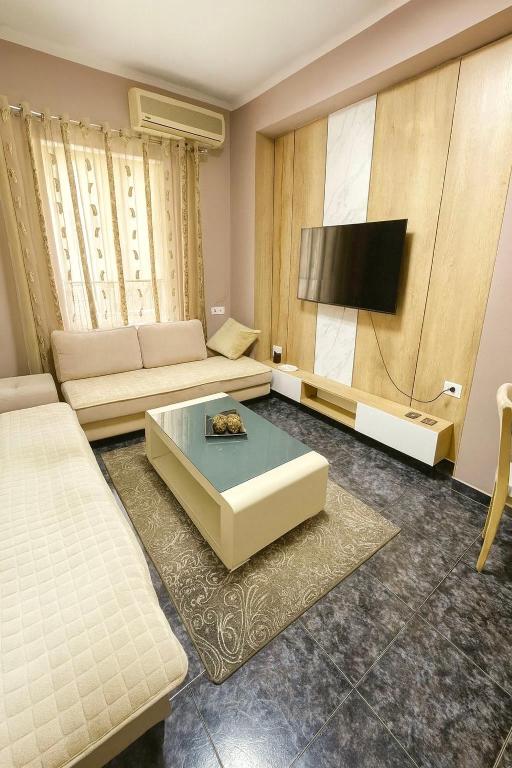 a living room with a couch and a flat screen tv at Midtown Cozy Apartment in Tirana