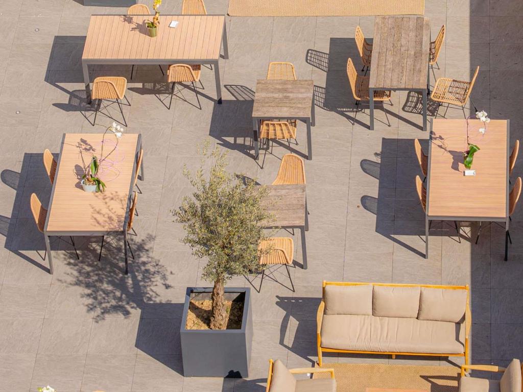 une vue aérienne de tables et de chaises dans une cour dans l'établissement Novotel Suites Paris Montreuil Vincennes, à Paris