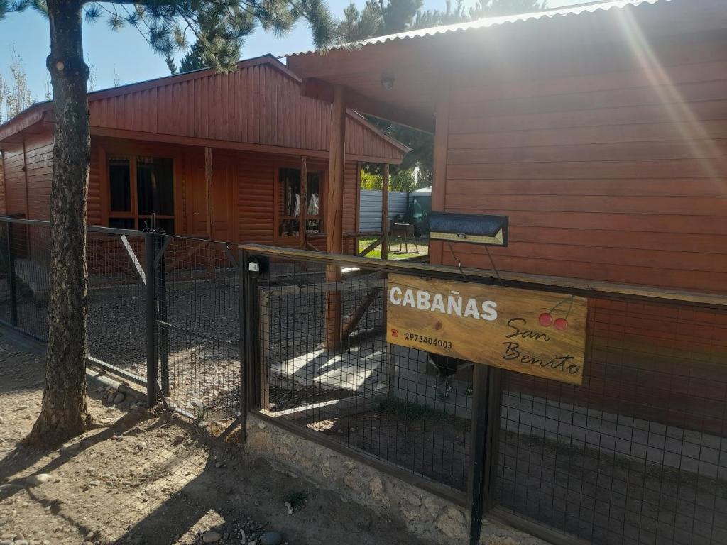 a fence with a sign in front of a house at Cabañas San Benito in Los Antiguos