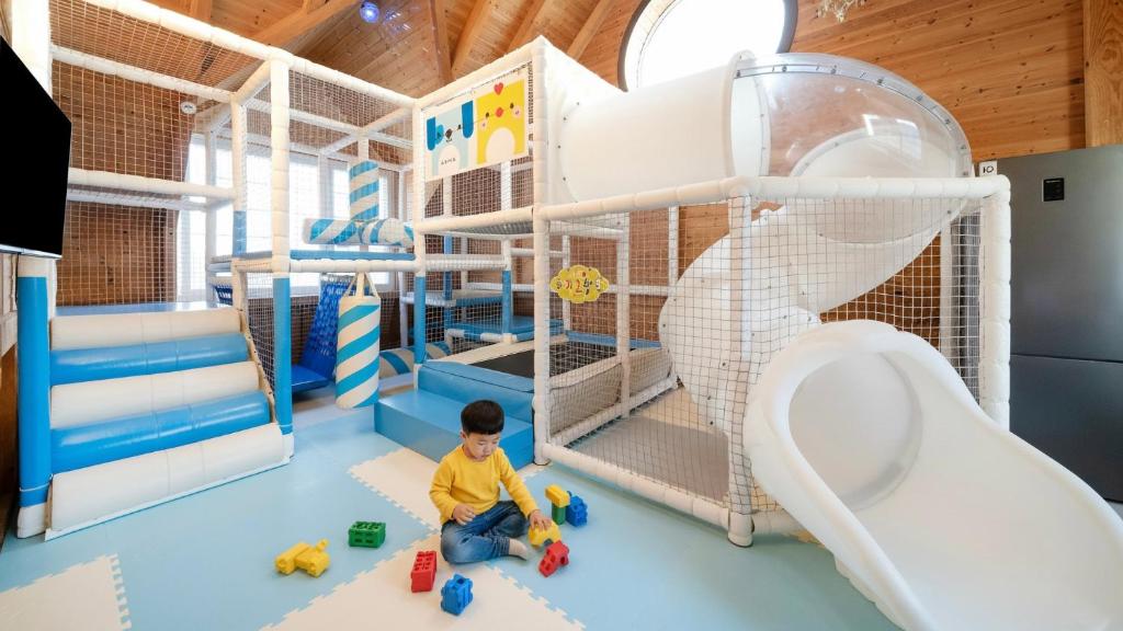 Ein Junge sitzt in einem Spielzimmer mit Toilette in der Unterkunft Gyeongju riu kids Poolvilla in Gyeongju