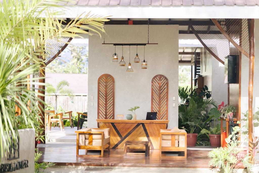 un patio con mesa, sillas y tablas de surf en Bellamar Villas, en El Nido