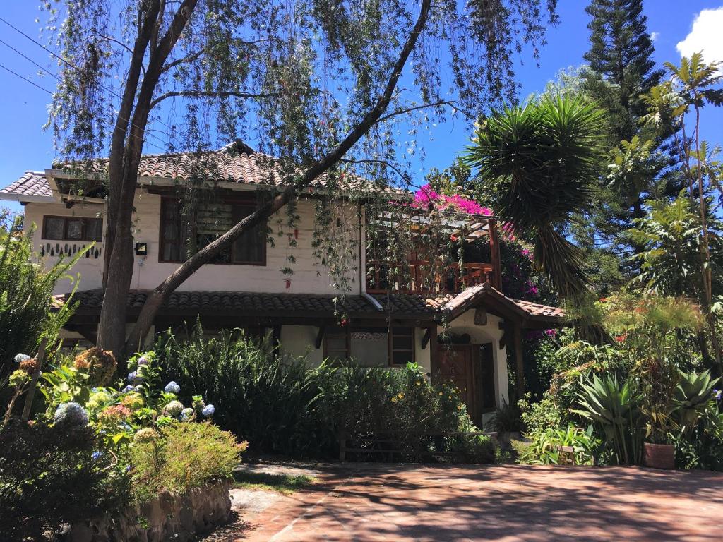 an old house with a garden in front of it at Casa Magnolia in Cumbayá