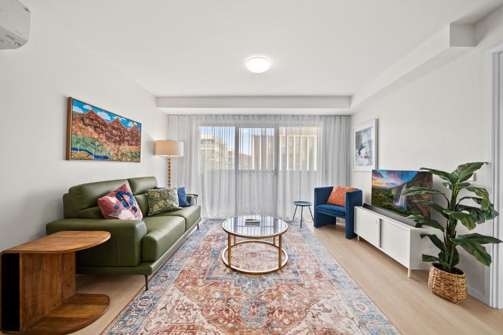 a living room with a couch and a table at Stylish 1-Bed Unit with Secure Parking in Braddon
