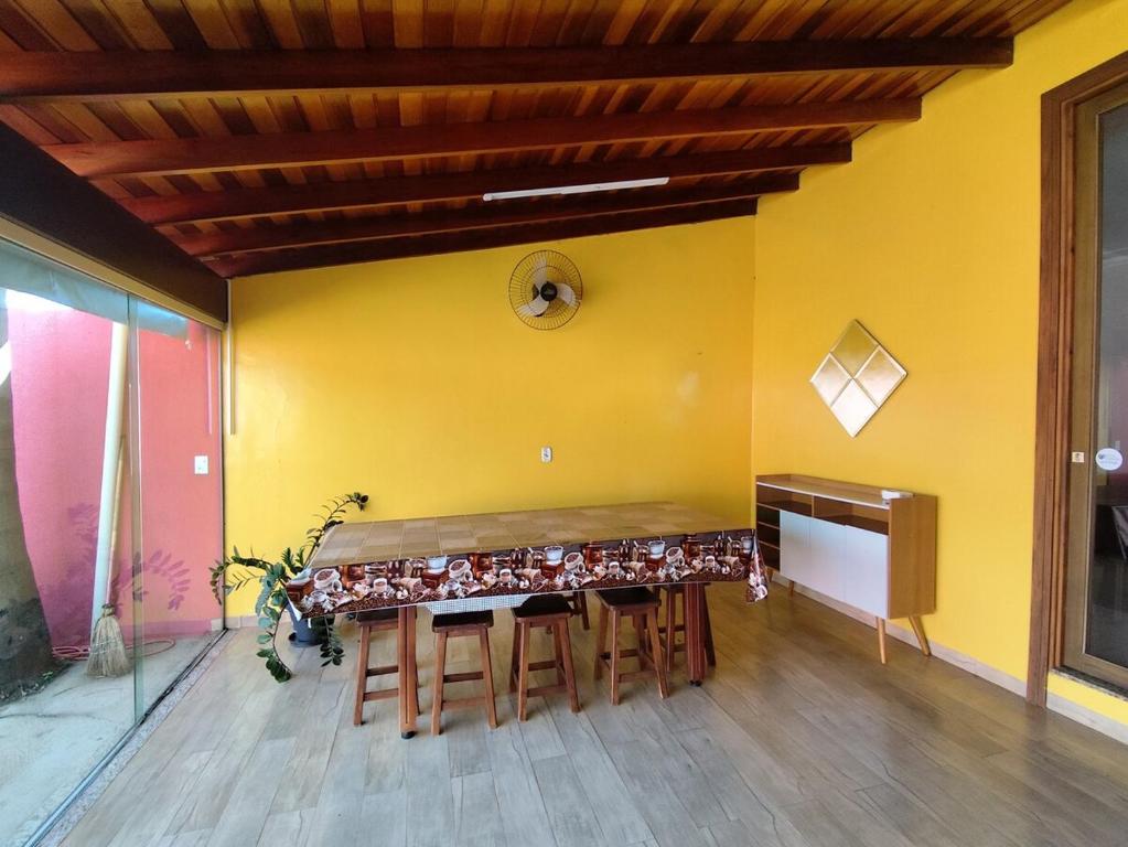 una stanza gialla con un tavolo e un pianoforte di Rancho Aconchego para seu lazer a Panorama