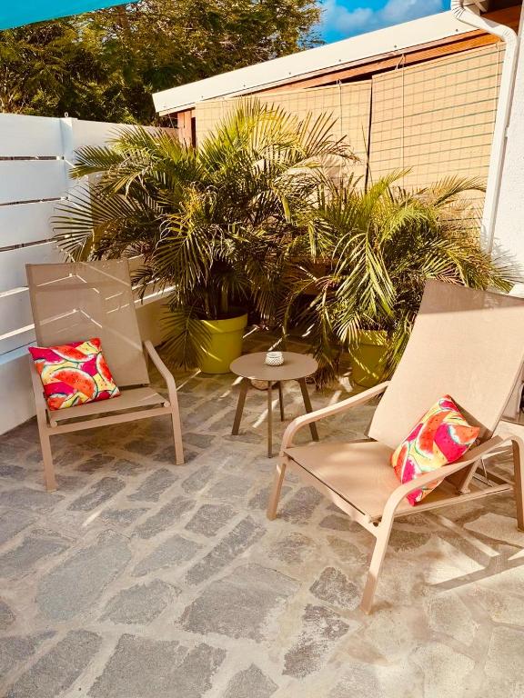 two chairs and a table on a patio at Orient bay Ti COCON au calme avec citerne in Orient Bay