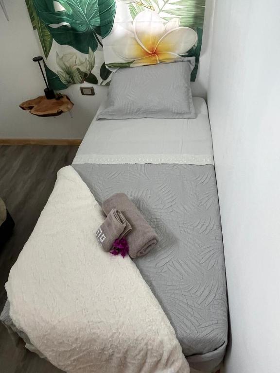 a twin bed with a flower on top of it at Cabaña Rei miro in Hanga Roa