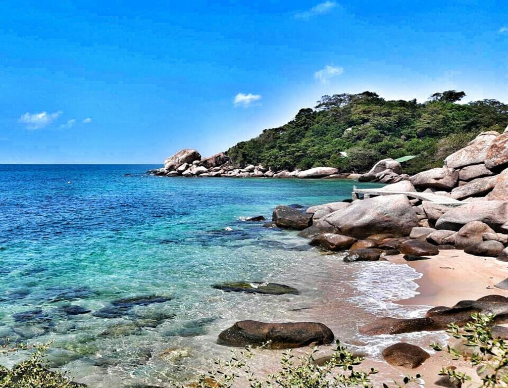 a beach with rocks and the ocean on a clear day at Tao Thong Villa 2 in Ko Tao