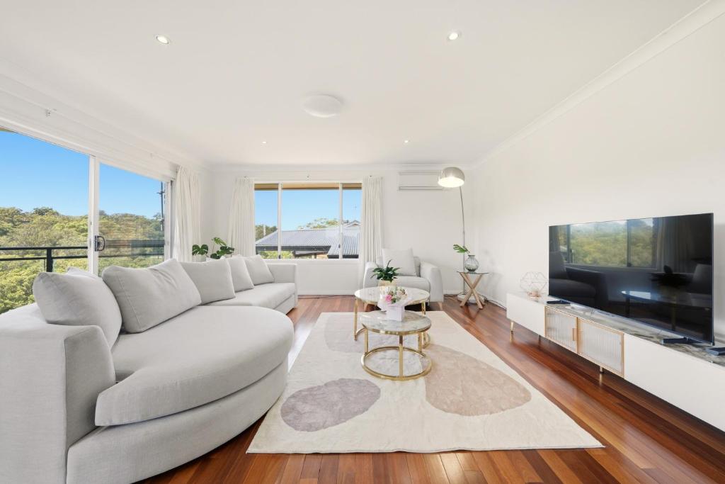 Una televisión o centro de entretenimiento en Luxury 4BR Home with River Views at Kareela