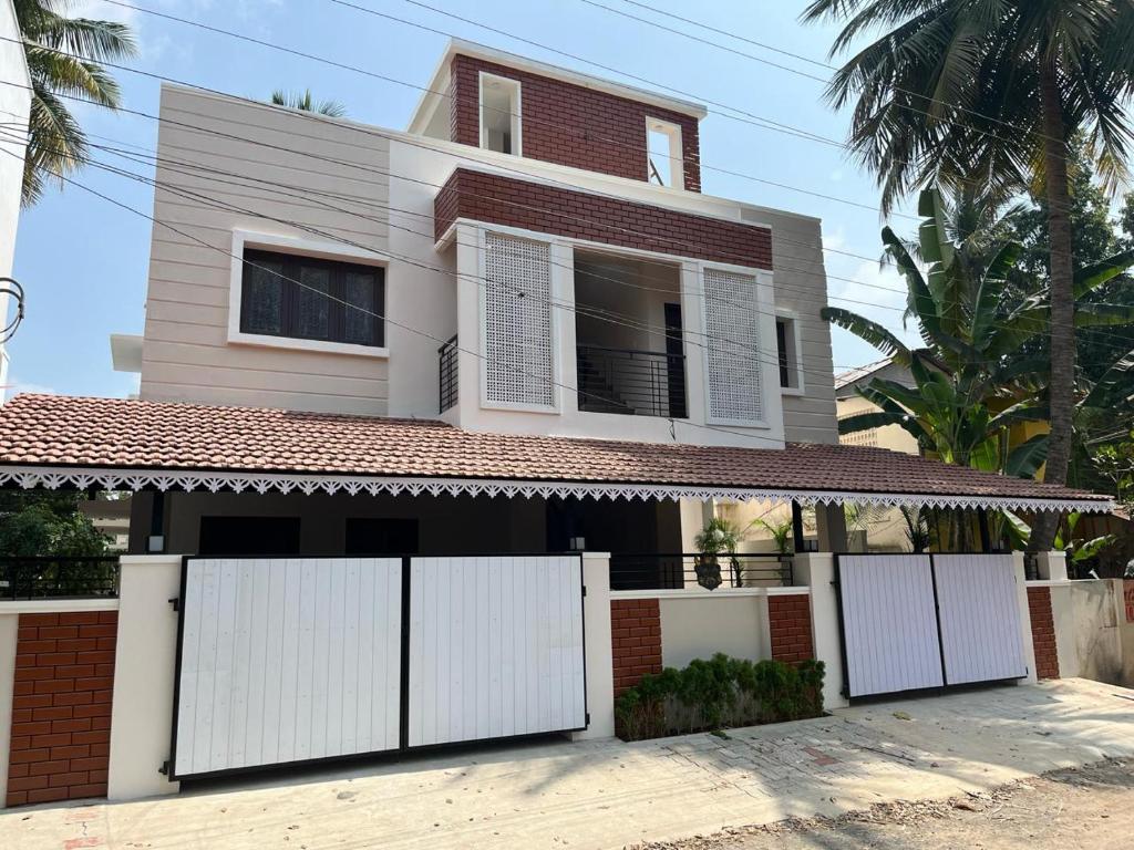 une maison avec des portes blanches devant elle dans l'établissement Raj Nivas, à Mayiladuthurai