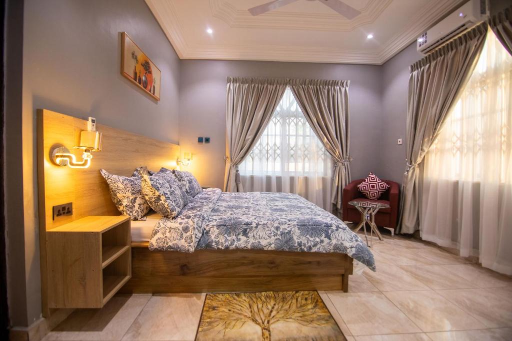 ein Schlafzimmer mit einem Bett mit einer blauen Bettdecke in der Unterkunft Glenwood Apartment in Amrahia