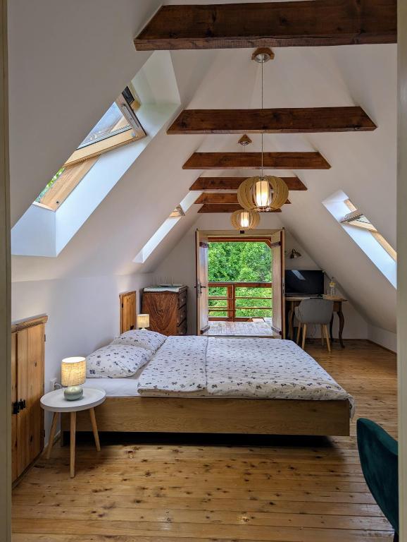 a bedroom with a bed in a room with skylights at The Village Cottage in Ocna de Jos