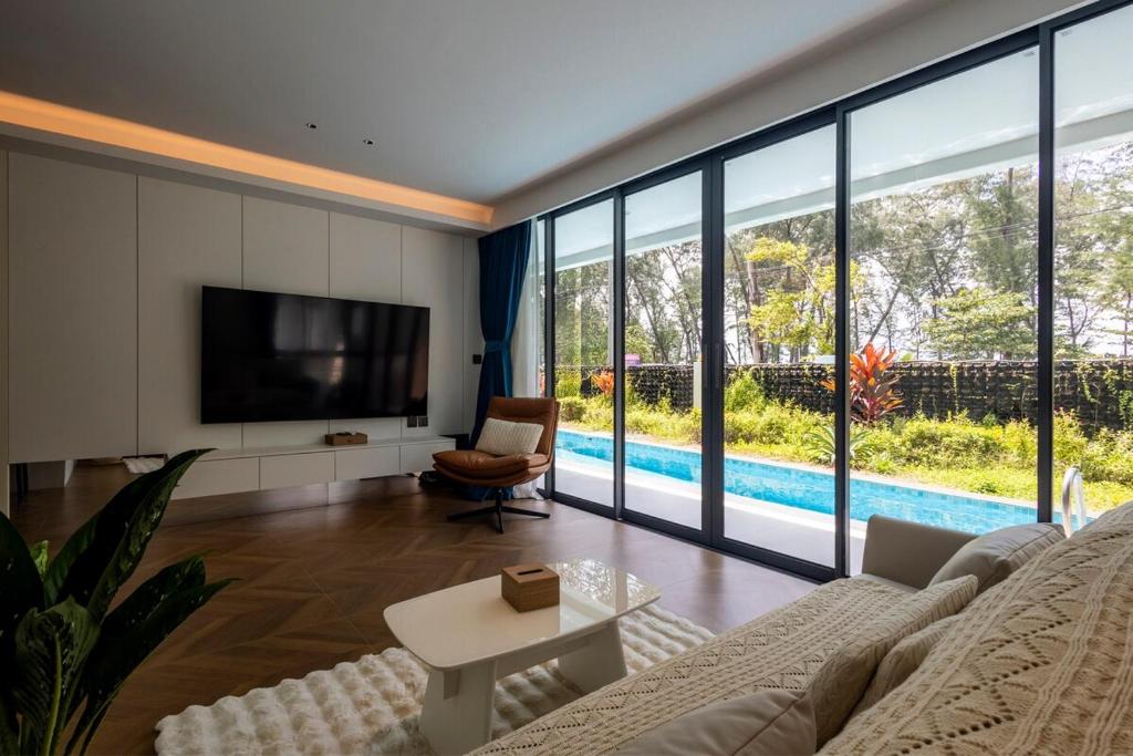 a living room with a couch and a tv at Kora 2br pool Apartment in Layan Beach