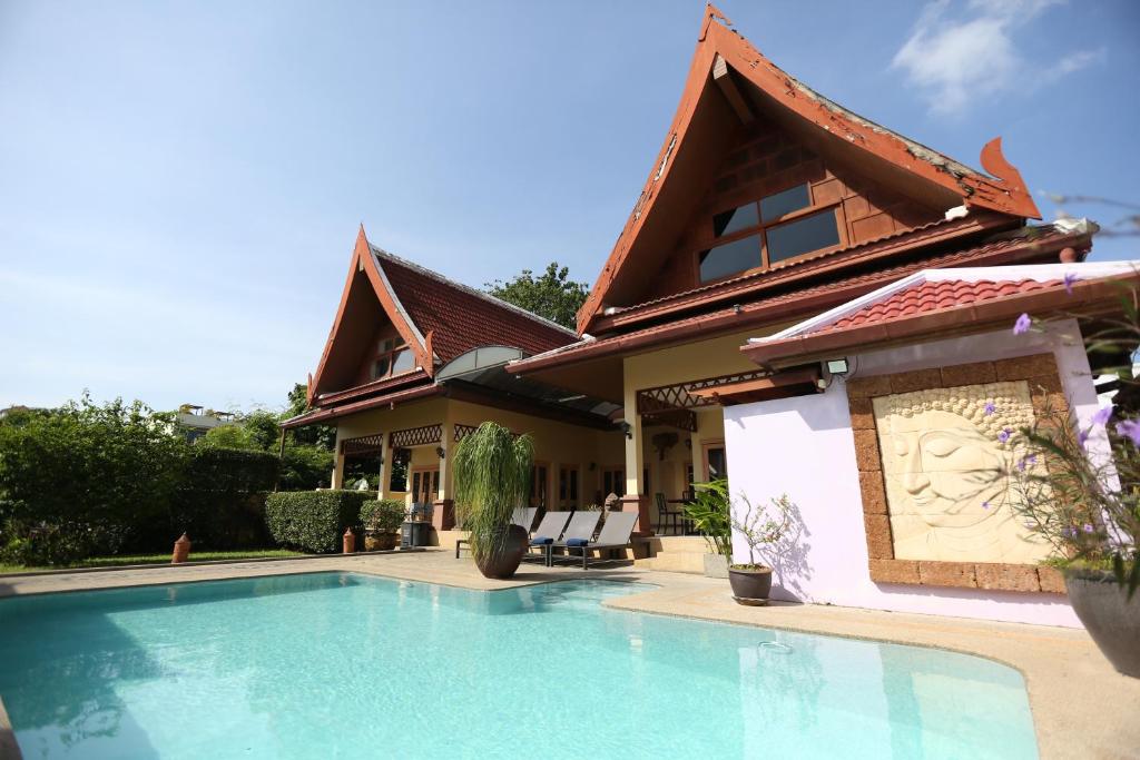 une maison avec une piscine devant dans l'établissement Beautiful 5BR Villa Felicity, Pool & Garden, near Naiharn, à Rawai Beach